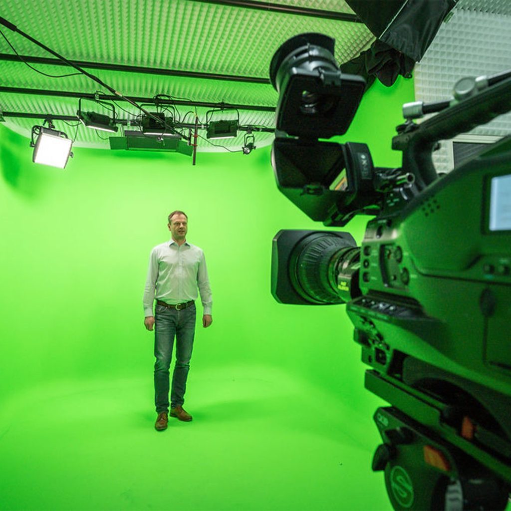 Mann steht im Greenscreen Studio von EMS Media Solutions