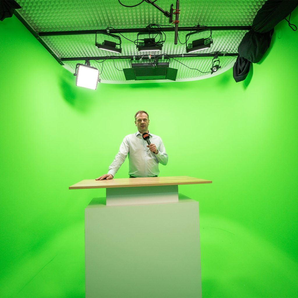 Mann steht an Pult im Greenscreen Studio von EMS GmbH im Filmstudio Nürnberg
